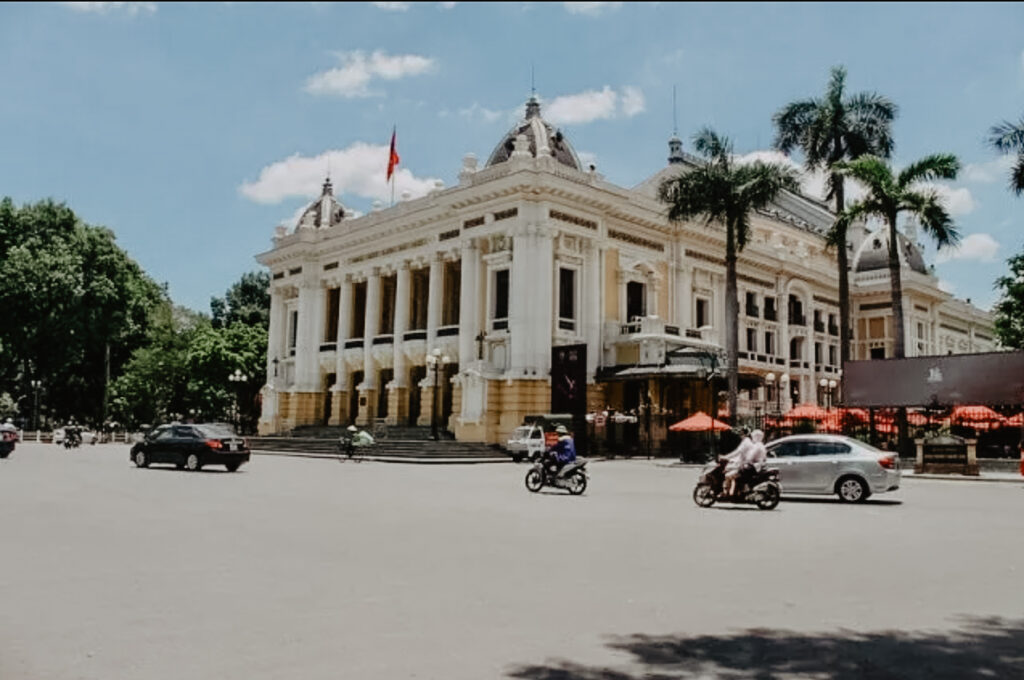 Imagen de Hanoi, muestra el tráfico frente a un edificio oficial
